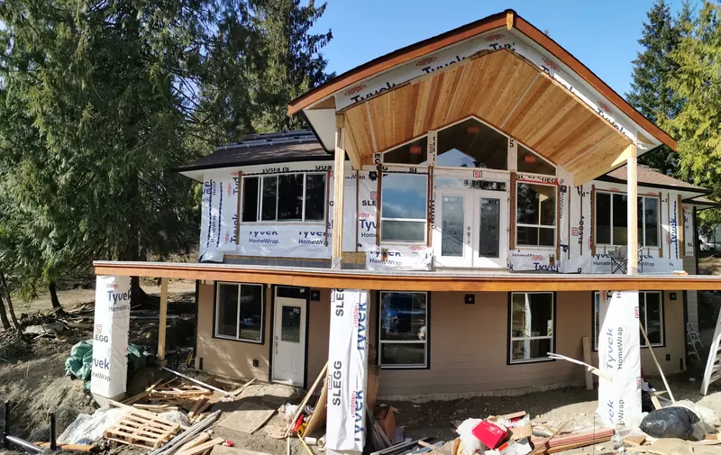 House addition framing with a vaulted cedar ceiling and house wrap