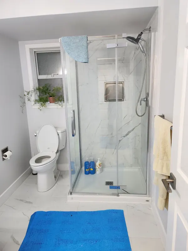 Bathroom with a glass-enclosed shower and marble-look tile