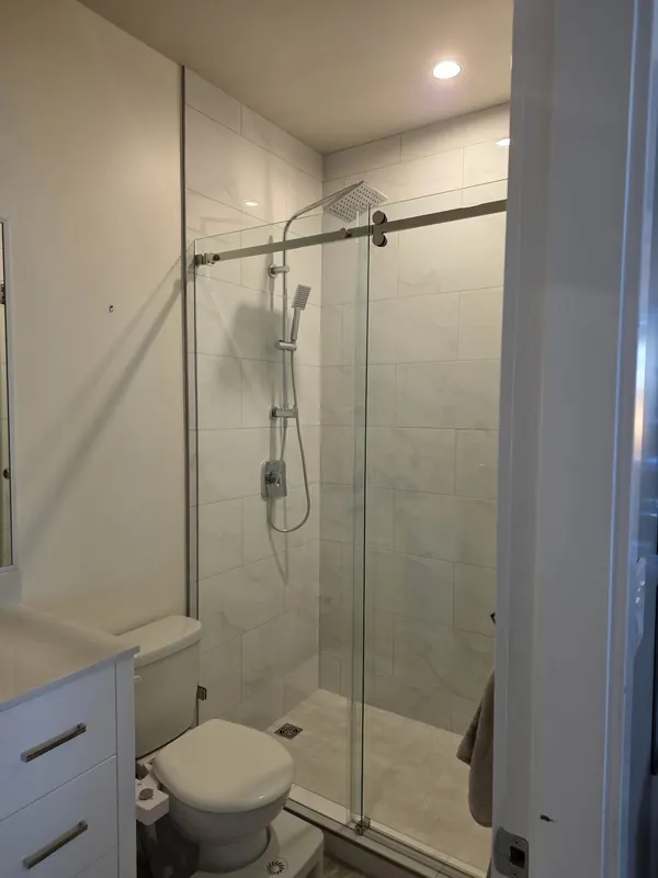 Bathroom with a sliding glass shower door and white tile