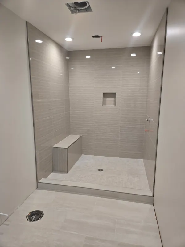 Finished walk-in tiled shower with bench and pot lights