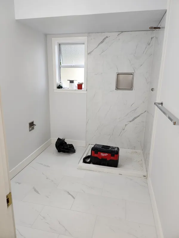 Bathroom with marble-look tile on the shower walls and floor