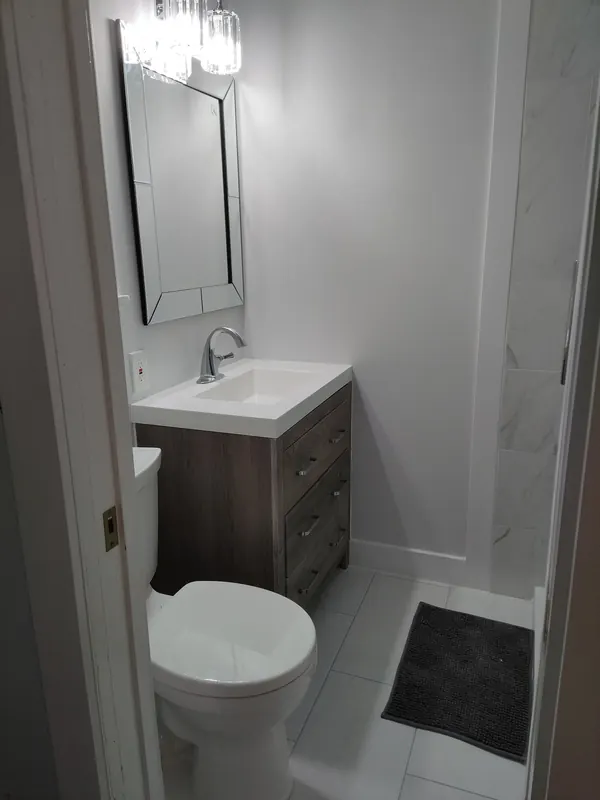 Small bathroom with a floating vanity and marble-look shower tile
