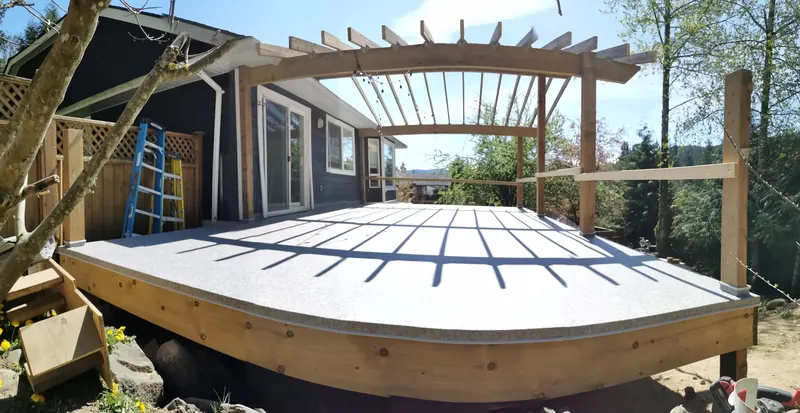 Curved deck frame with a cedar pergola going up over it