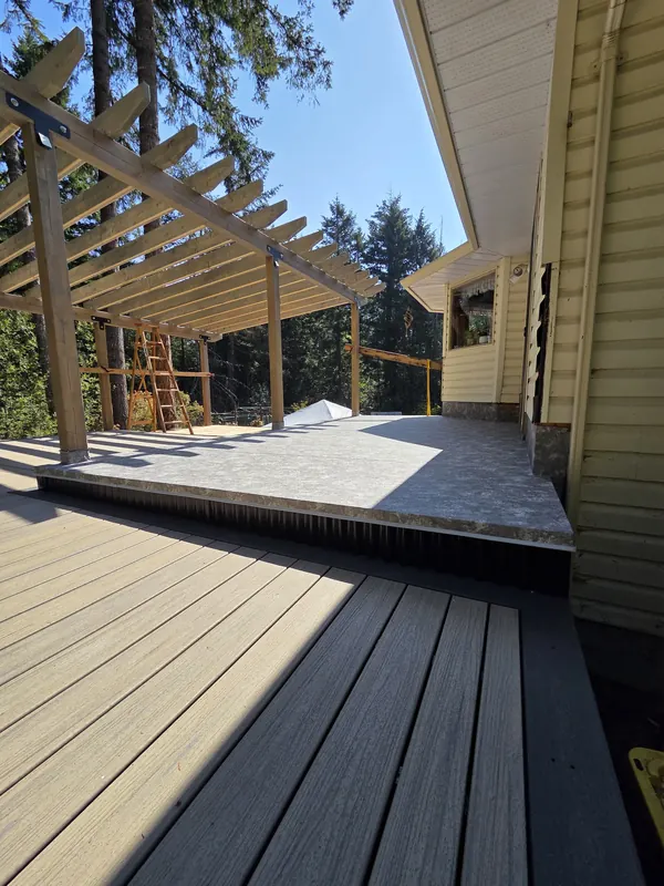 Two-tone composite deck boards beside a cedar pergola