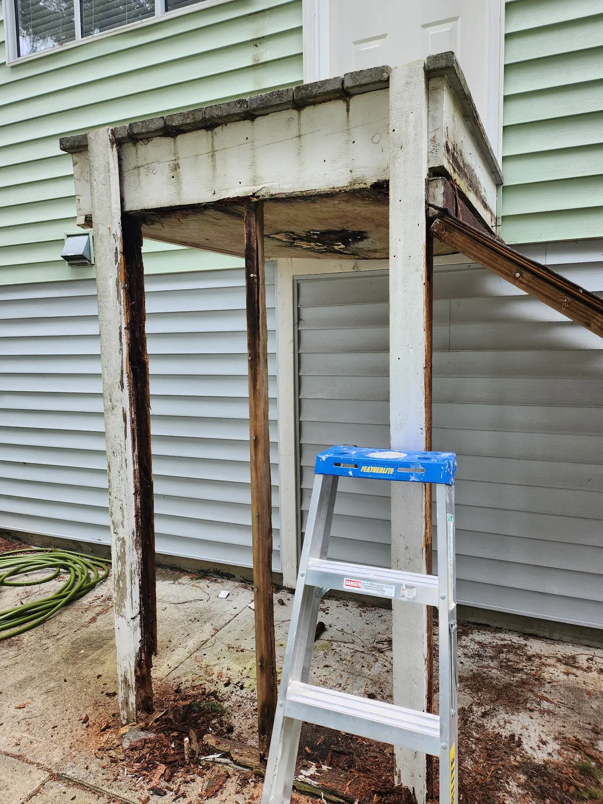 Rotted porch posts and landing before being rebuilt