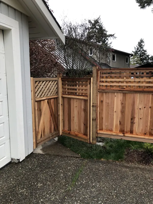 Cedar fence and gate with lattice top beside a garage