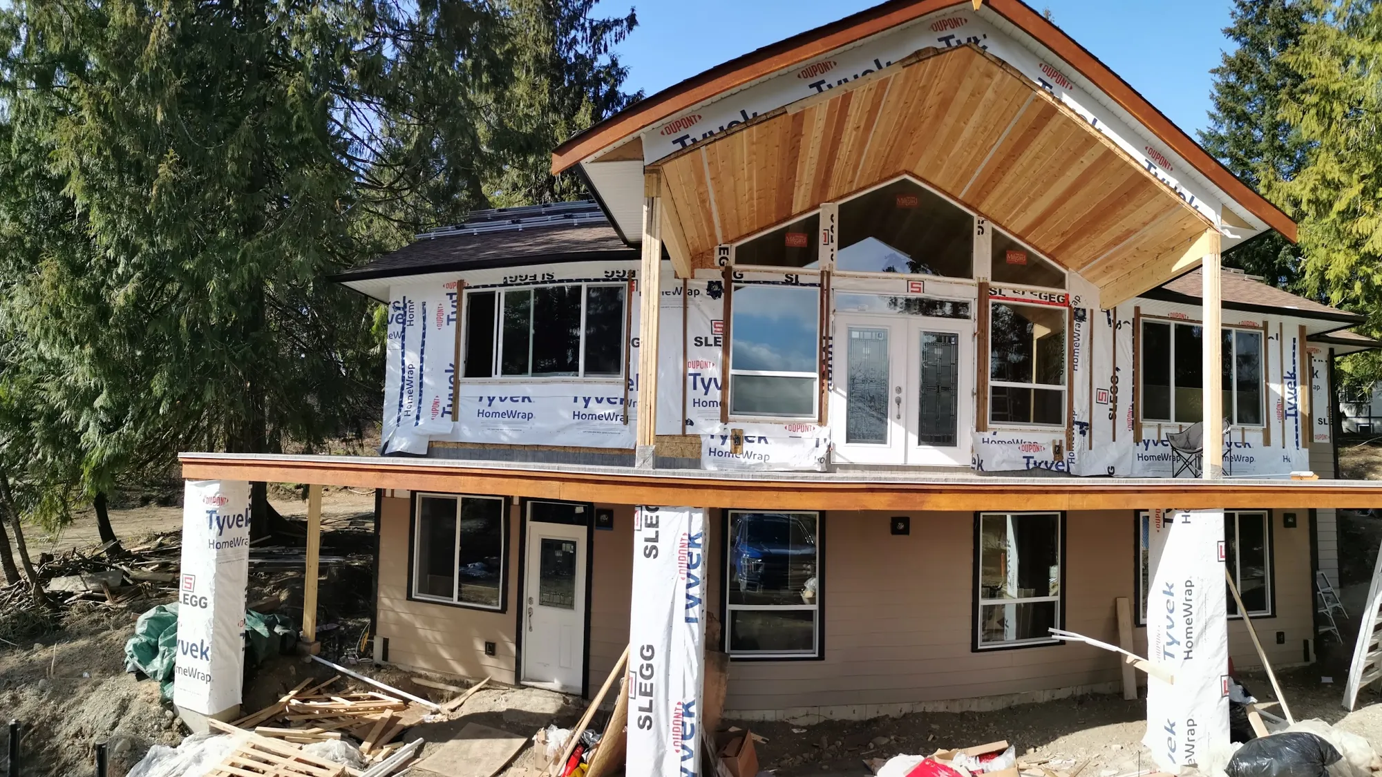 House addition framing with a vaulted cedar ceiling and house wrap