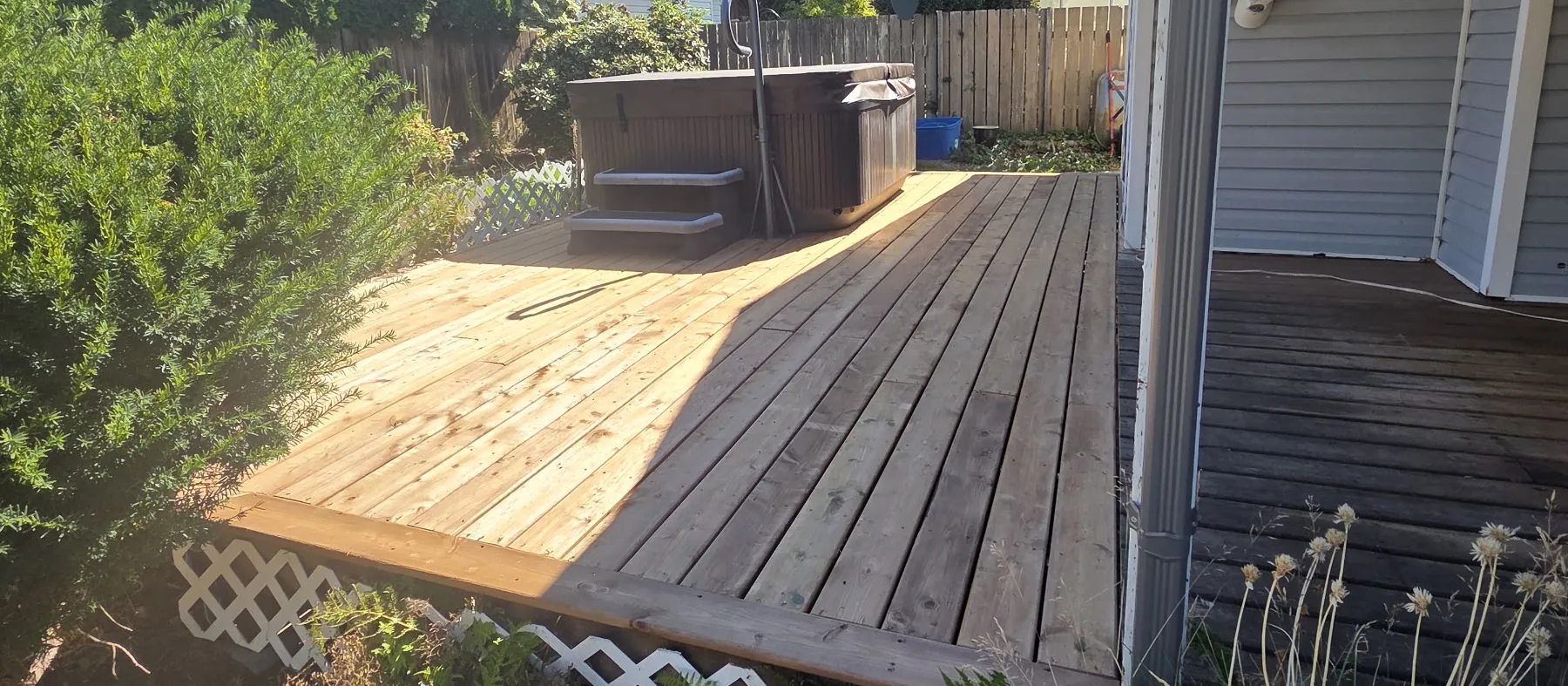 Deck being re-boarded with new light boards next to the old weathered ones