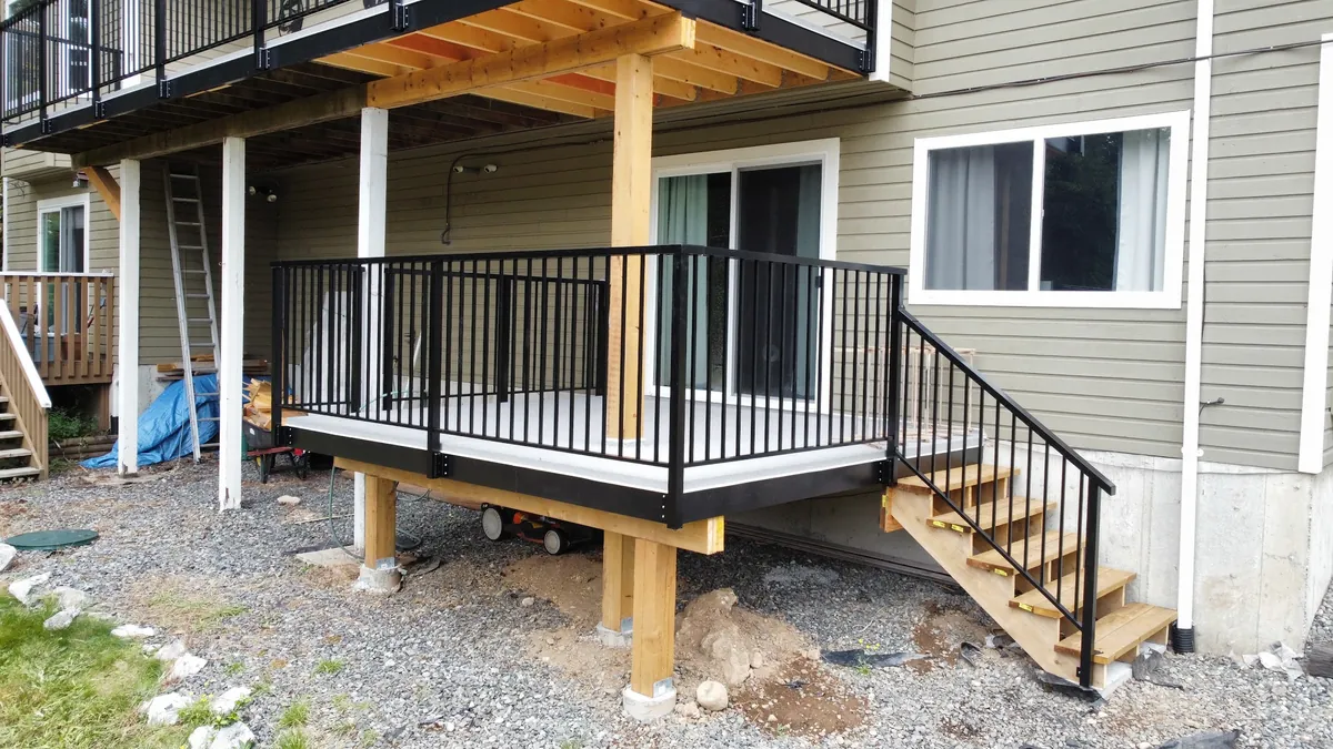 New elevated deck on cedar posts with black railing and stairs