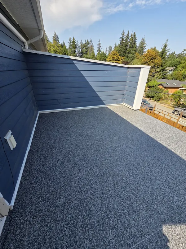 Charcoal flake vinyl deck framed by a blue-clad parapet wall