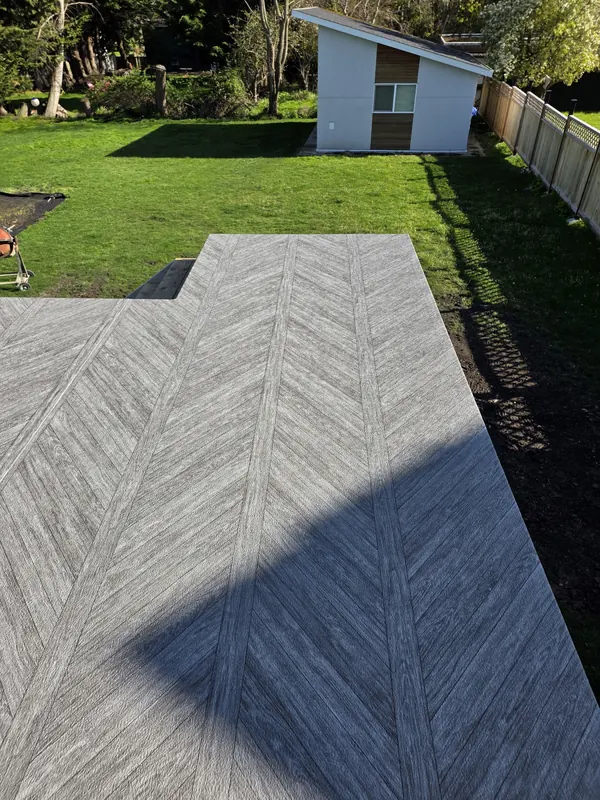 Grey herringbone-pattern vinyl deck built out onto a lawn